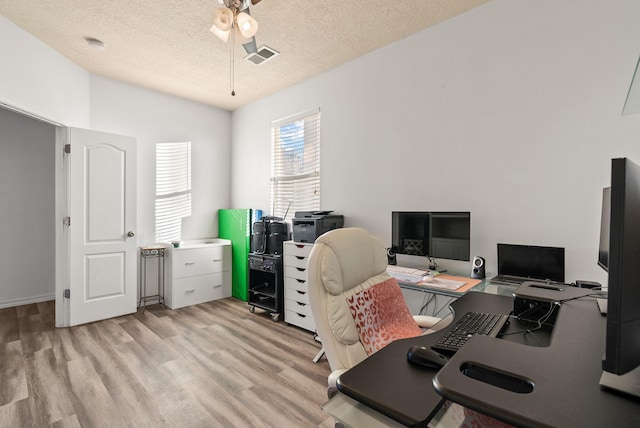 office area with a textured ceiling and light hardwood / wood-style flooring