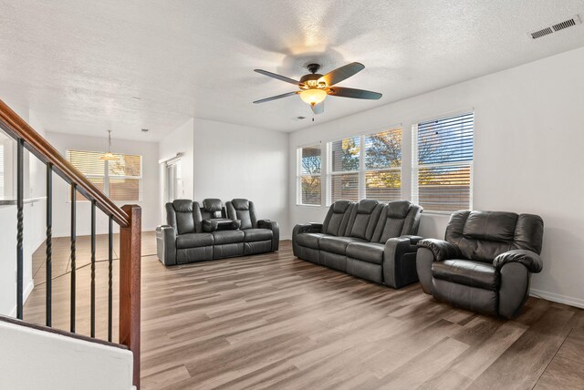 6923 Wrangell Loop NE, Rio Rancho, NM 87144 - living area featuring light wood-style floors, a textured ceiling, a ceiling fan, baseboards, and stairway