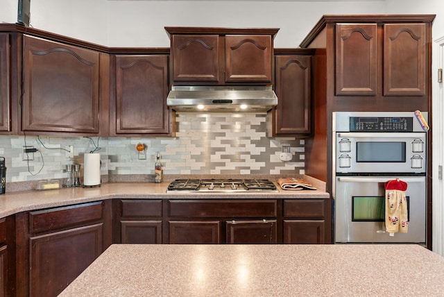 kitchen featuring decorative backsplash, dark brown cabinetry, stainless steel appliances, and extractor fan