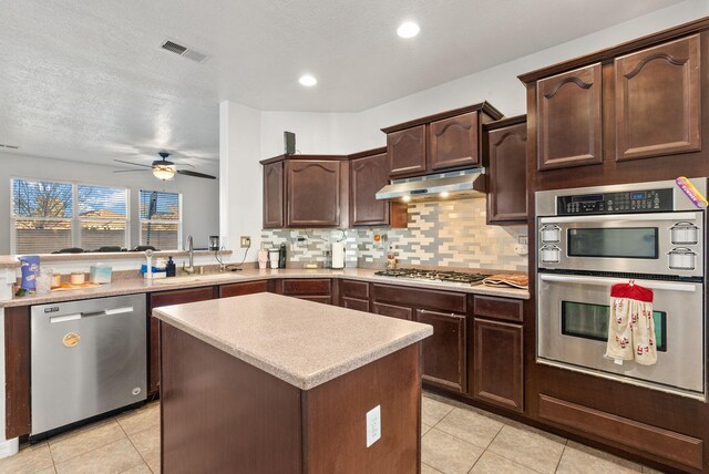 6923 Wrangell Loop NE, Rio Rancho, NM 87144 - kitchen featuring appliances with stainless steel finishes, a sink, under cabinet range hood, light tile patterned flooring, and recessed lighting