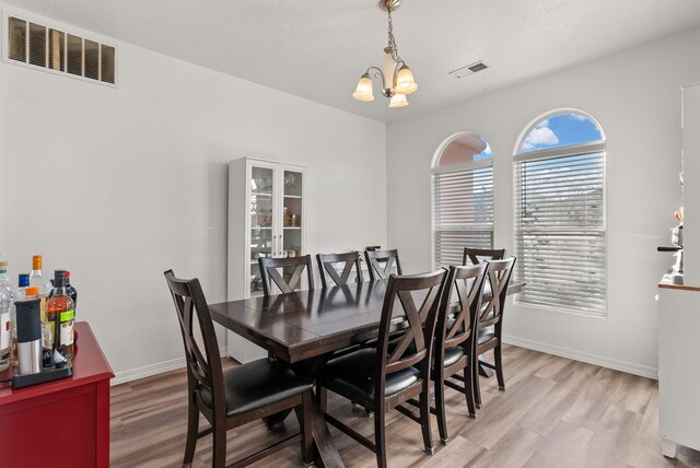 6923 Wrangell Loop NE, Rio Rancho, NM 87144 - dining space with a chandelier, light wood-style flooring, and baseboards
