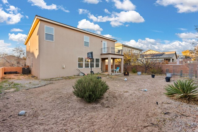 6923 Wrangell Loop NE, Rio Rancho, NM 87144 - back of property with a balcony, a fenced backyard, stucco siding, a patio area, and central AC unit