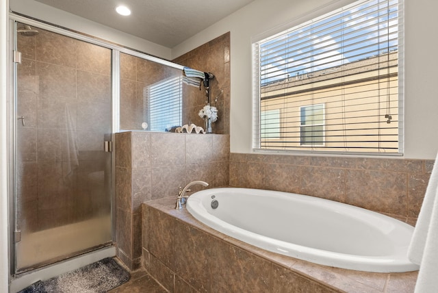 bathroom featuring shower with separate bathtub and a textured ceiling