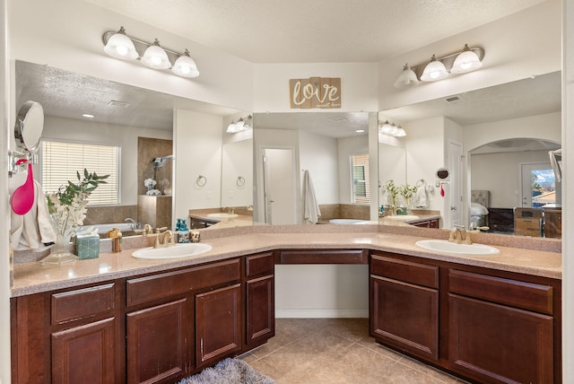 bathroom with tile patterned floors, vanity, plus walk in shower, and a textured ceiling