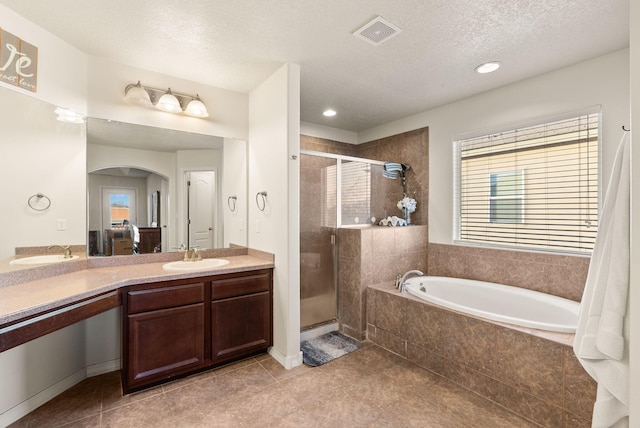 bathroom featuring separate shower and tub, tile patterned flooring, vanity, and a textured ceiling