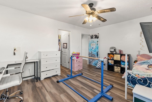 bedroom featuring dark hardwood / wood-style floors, ceiling fan, and a textured ceiling