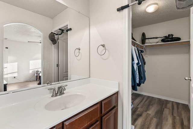 bathroom featuring vanity, a textured ceiling, hardwood / wood-style flooring, and ceiling fan