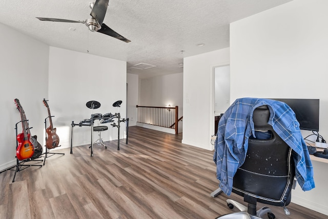 home office featuring ceiling fan, wood-type flooring, and a textured ceiling