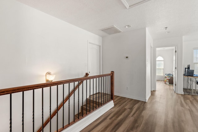 6923 Wrangell Loop NE, Rio Rancho, NM 87144 - hallway featuring wood finished floors, an upstairs landing, a textured ceiling, and baseboards