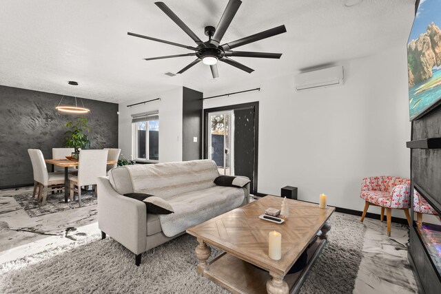 living room with a textured ceiling, ceiling fan, and a wall mounted air conditioner