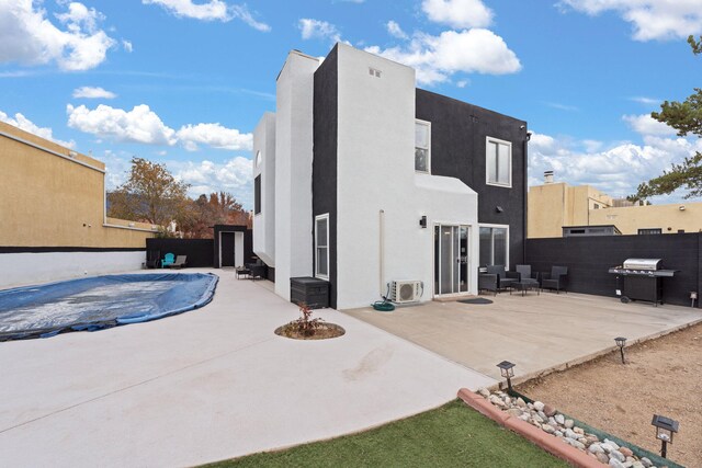 rear view of property featuring a patio area and a covered pool