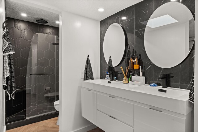 bathroom with walk in shower, parquet flooring, a textured ceiling, toilet, and vanity