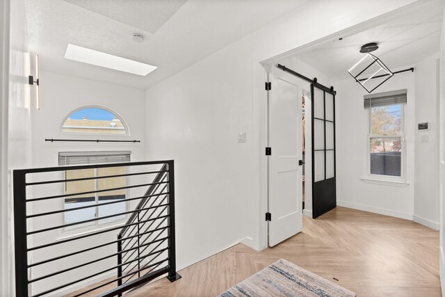 foyer with a barn door and light parquet floors