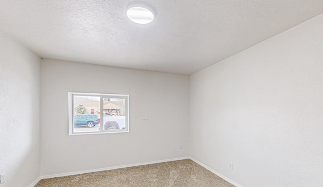 spare room featuring carpet and a textured ceiling