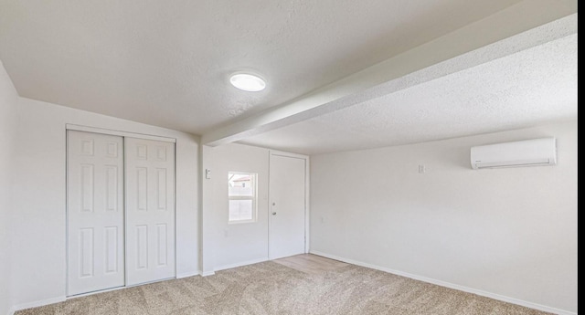 interior space with carpet flooring, a textured ceiling, and a wall unit AC