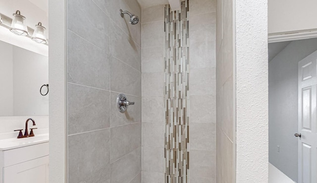 bathroom with vanity and tiled shower