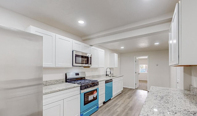 kitchen featuring white cabinetry, sink, light stone countertops, light hardwood / wood-style floors, and appliances with stainless steel finishes