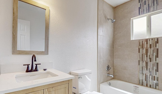 full bathroom featuring toilet, vanity, and tiled shower / bath