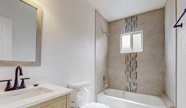 full bathroom with vanity, tiled shower / bath combo, and toilet