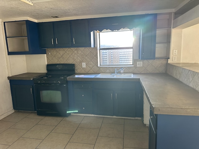 kitchen with black gas range, sink, light tile patterned flooring, and blue cabinets