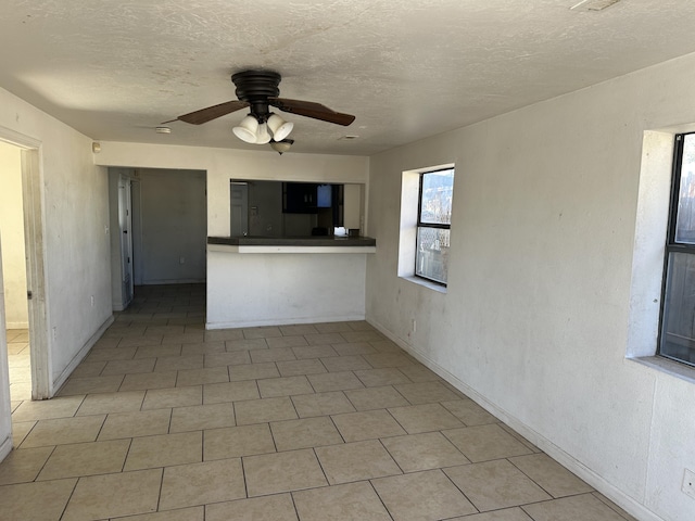 interior space with ceiling fan and a textured ceiling