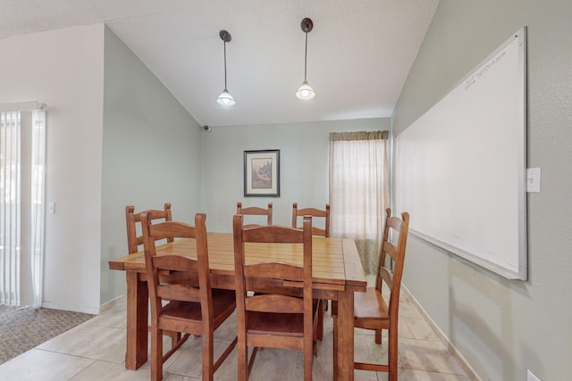 dining area with lofted ceiling and light tile patterned floors