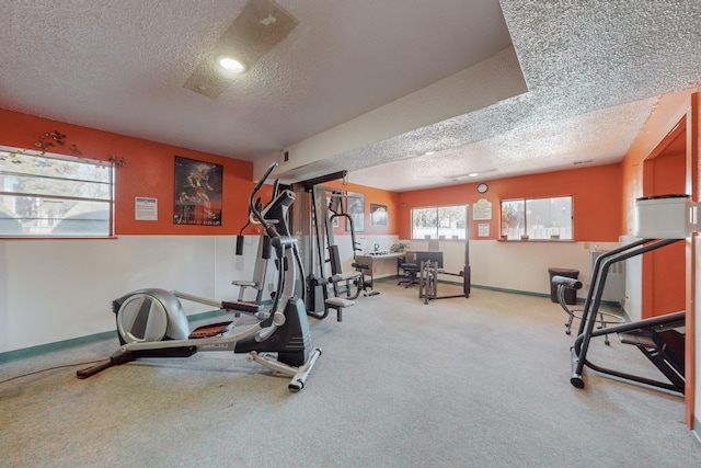 exercise area featuring carpet and a textured ceiling