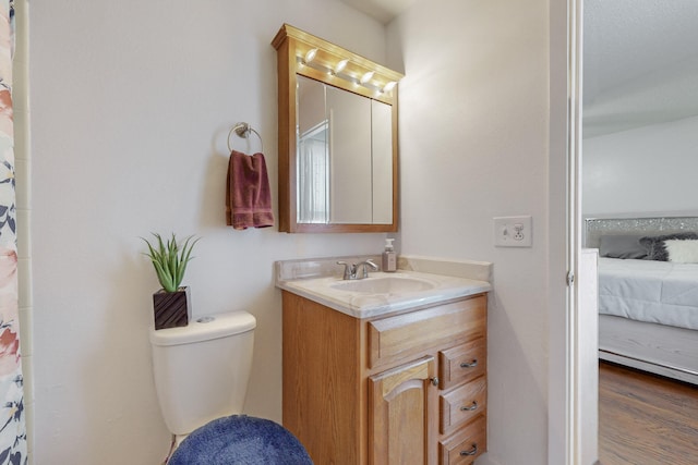 bathroom featuring vanity, hardwood / wood-style flooring, and toilet