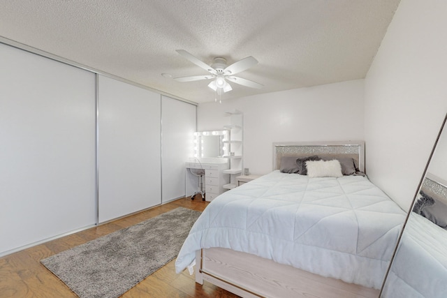 bedroom featuring a closet, a textured ceiling, hardwood / wood-style flooring, and ceiling fan