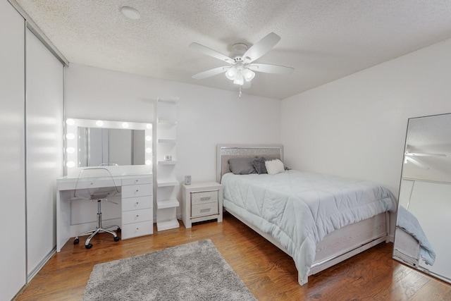 bedroom featuring ceiling fan, a textured ceiling, and hardwood / wood-style flooring