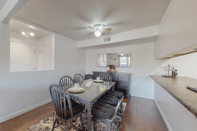 dining space with a textured ceiling, ceiling fan, and dark wood-type flooring