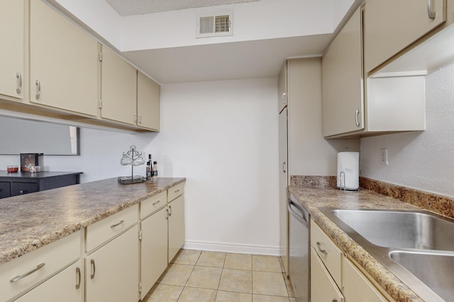 kitchen featuring dishwasher, cream cabinets, light tile patterned flooring, and sink