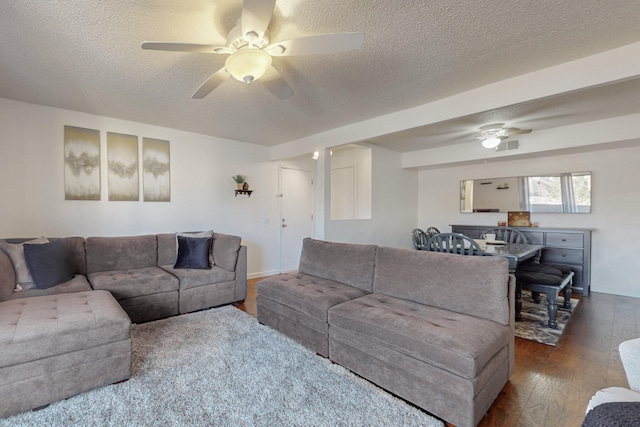 living room with a textured ceiling, hardwood / wood-style flooring, and ceiling fan