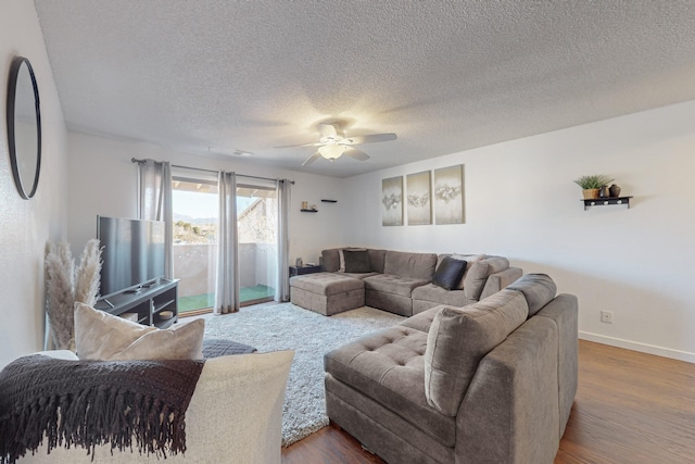 living room with hardwood / wood-style floors, ceiling fan, and a textured ceiling