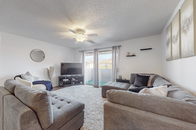 living room with ceiling fan, carpet, and a textured ceiling