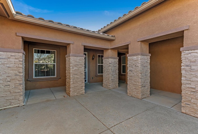 view of exterior entry featuring a patio