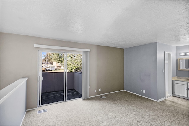 carpeted spare room with a textured ceiling