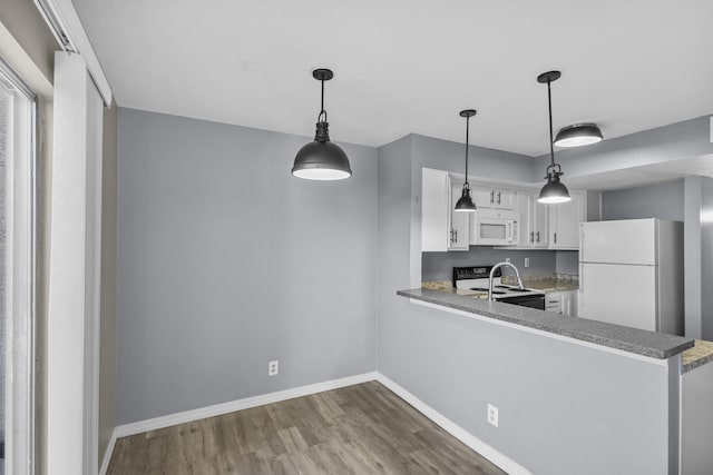 kitchen featuring white cabinetry, white appliances, kitchen peninsula, and hanging light fixtures