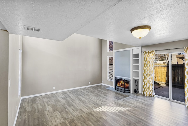 unfurnished living room featuring a textured ceiling and hardwood / wood-style flooring