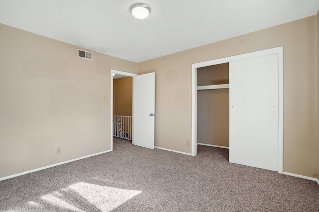 unfurnished bedroom featuring a closet, carpet, and a textured ceiling