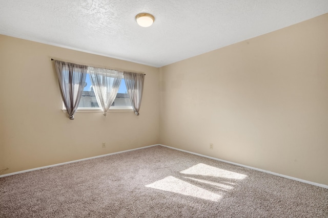 carpeted empty room featuring a textured ceiling