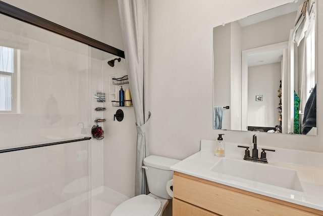 bathroom featuring vanity, toilet, and a shower with shower door