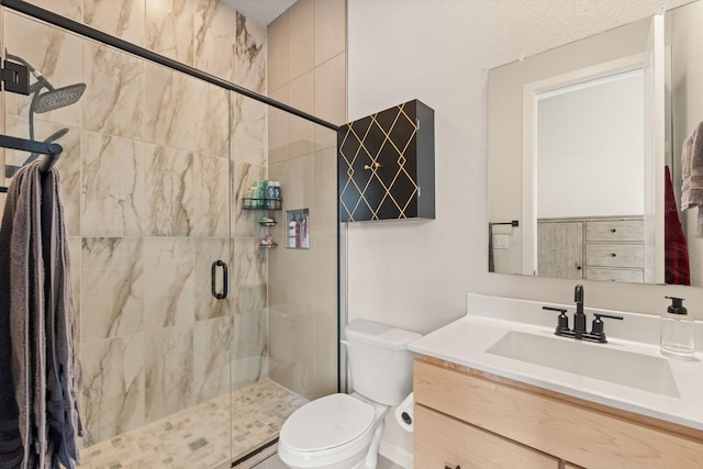 bathroom featuring vanity, toilet, and a shower with shower door