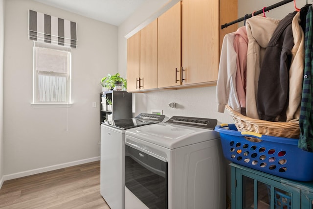 washroom with independent washer and dryer, cabinets, and light wood-type flooring