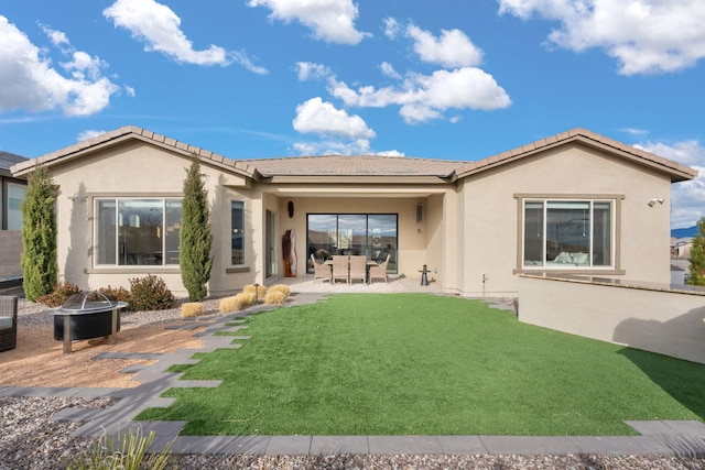 rear view of house with a lawn, a patio area, and a fire pit