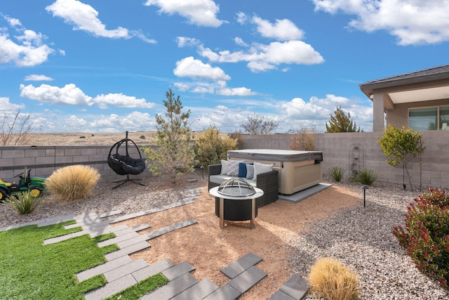 view of patio featuring a hot tub and an outdoor fire pit