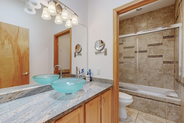 full bathroom with tile patterned flooring, vanity, enclosed tub / shower combo, and toilet