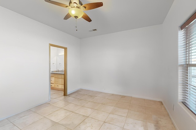 tiled empty room with ceiling fan