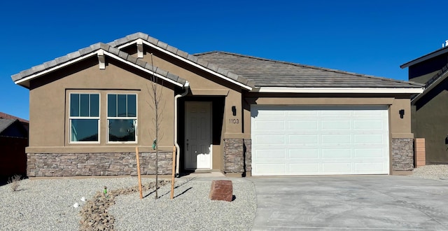 view of front of property with a garage, driveway, stone siding, and stucco siding