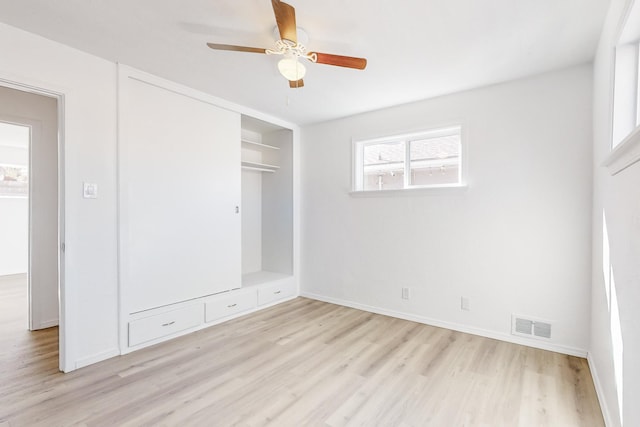 unfurnished bedroom featuring a closet, light hardwood / wood-style floors, and ceiling fan